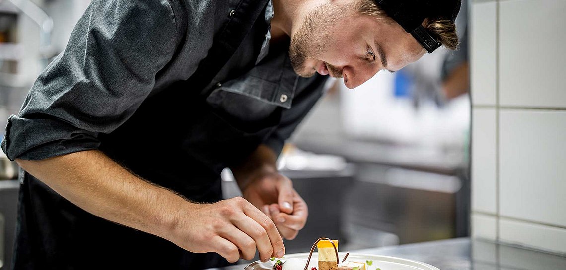 Koch bei der Dekoration der Teller