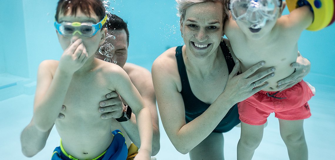 Familie taucht im Schwimmbad unter
