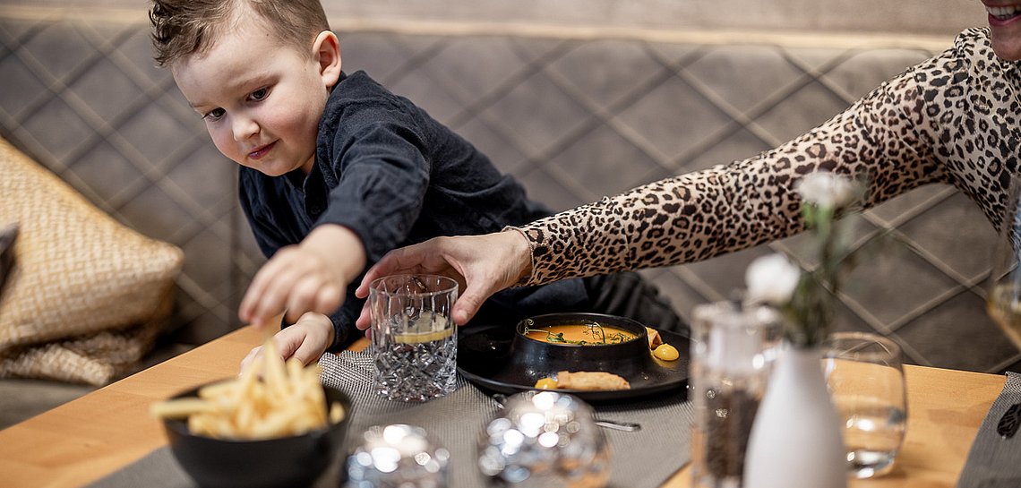 Kind beim Abendessen im Speisesaal
